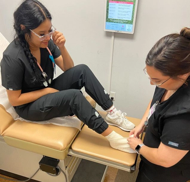 students in lab practicing vitals in patient room